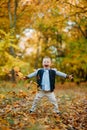 Rapturous and happy child boy stands in autumn forest