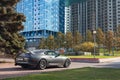 A rare Japanese sports car in the back of a Toyota Supra coupe in gray with a spoiler in park of city near trees with yellow