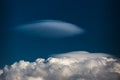 Rare Lenticular cloud Altocumulus lenticularis on top of a cumulus cloud in front of a blue sky Royalty Free Stock Photo