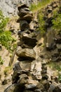 Man made stone tower outdoor, with unique basalt rock formation wall background.