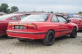 Elegant old red coupe car Mazda 626 at a car show