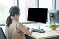 Rare view of attractive and smile young asian customer servicer woman wearing headset in modern creative meeting working office Royalty Free Stock Photo