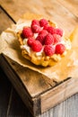 Rasberry cake decorated with fresh ripe berries on the rustic background