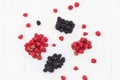 Raspberries and blackberries white wooden background