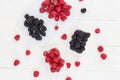 Raspberries and blackberries white wooden background