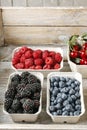 Raspberries, blueberries, blackberries and cherries in carton boxes Royalty Free Stock Photo