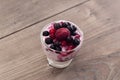 Raspberries, blueberries, blackberries mixed with natural yogurt inside a small glass on a table Royalty Free Stock Photo