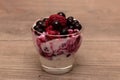 Raspberries, blueberries, blackberries mixed with natural yogurt inside a small glass Royalty Free Stock Photo