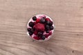 Raspberries, blueberries, blackberries mixed with natural yogurt inside a small glass Royalty Free Stock Photo