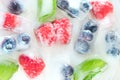 Raspberries, blueberries and mint leaves in ice cubes