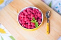 Raspberries in ceramic bowl. Ripe and tasty raspberries on a wooden background. Royalty Free Stock Photo