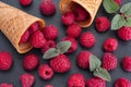 Raspberries and mint leaves spilling out of ice cream cones