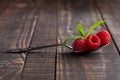 Raspberries on old spoon and mint on grunge wooden board