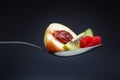 Raspberries, peach and kiwi on curved spoon
