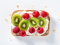 Raspberries and pieces of kiwi on a piece of bread spread with cream cheese. White background