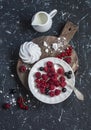Raspberries, red and blackcurrants, a meringue, cream on a rustic cutting board Royalty Free Stock Photo