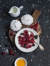 Raspberries, red and blackcurrants, a meringue, cream on a rustic cutting board Royalty Free Stock Photo