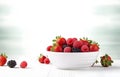 raspberries, strawberries, blackberries, wild strawberries, blueberries on white plate on white wooden table for food card design Royalty Free Stock Photo