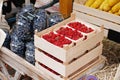 Raspberries in wooden boxes and blueberries in glass jars