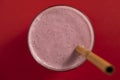Raspberry banana smoothie in glass on a red background, closeup, top view Royalty Free Stock Photo