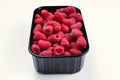 Raspberry in black container isolated on white background Royalty Free Stock Photo