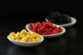 Raspberry, blackberries and dogeberry in white plate on black background Royalty Free Stock Photo