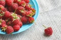 Raspberry in blue dish and in front of white fabric on old v Royalty Free Stock Photo