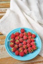 Raspberry in blue dish and in front of white fabric on old vi Royalty Free Stock Photo
