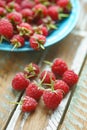 Raspberry in blue dish on old vintage wooden table. Royalty Free Stock Photo