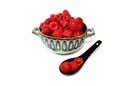 Raspberry in bowl, berries in clay plate, red fruit in dish next to black ceramic spoon, red fruit in cup, close up.