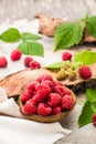 Raspberry in a bowl, berries and leaves on a shabby wood