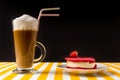 A raspberry cake on a white saucer, an Irish Cup of coffee with milk on a black background. Royalty Free Stock Photo