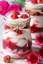 Raspberry dessert in a jar and flower on a table, vertical Royalty Free Stock Photo