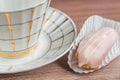 Raspberry eclair and cup of tea on wooden table Royalty Free Stock Photo