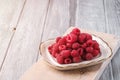 Raspberry fruits in plate on old cutting board, healthy pile of summer berries on grey wooden background Royalty Free Stock Photo