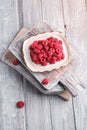 Raspberry fruits in plate on old cutting boards, healthy pile of summer berries on grey wooden background Royalty Free Stock Photo