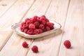 Raspberry fruits in white plate, healthy pile of summer berries on wooden background Royalty Free Stock Photo