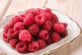 Raspberry fruits in white plate, healthy pile of summer berries on wooden background Royalty Free Stock Photo