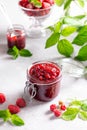 Raspberry jam in a glass jar with fresh raspberry berries on a light concrete background. Vertical Royalty Free Stock Photo