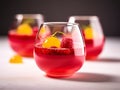 Raspberry jelly decorated with fruit and mint leaves, on white table