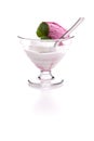 Raspberry and lemon ice cream scoop in a glass with a spoon and mint leaf with shadow in front