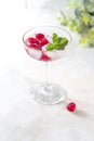 Raspberry lemonade with mint and ice in a glass on a light concrete background Royalty Free Stock Photo