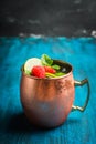 Raspberry and lime cocktail in copper mug variation of Moscow mule on the rustic background Royalty Free Stock Photo