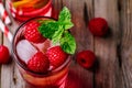 Raspberry Mojito Lemonade with lime and fresh mint in glass on wooden background Royalty Free Stock Photo