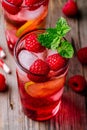 Raspberry Mojito Lemonade with lime and fresh mint in glass on wooden background Royalty Free Stock Photo