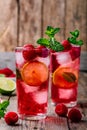 Raspberry Mojito Lemonade with lime and fresh mint in glass on wooden background Royalty Free Stock Photo