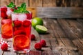 Raspberry Mojito Lemonade with lime and fresh mint in glass on wooden background