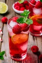 Raspberry Mojito Lemonade with lime and fresh mint in glass on wooden background Royalty Free Stock Photo