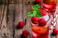 Raspberry Mojito Lemonade with lime and fresh mint in glass on wooden background Royalty Free Stock Photo