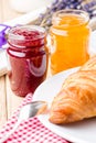 Raspberry and orange jam with croissant.